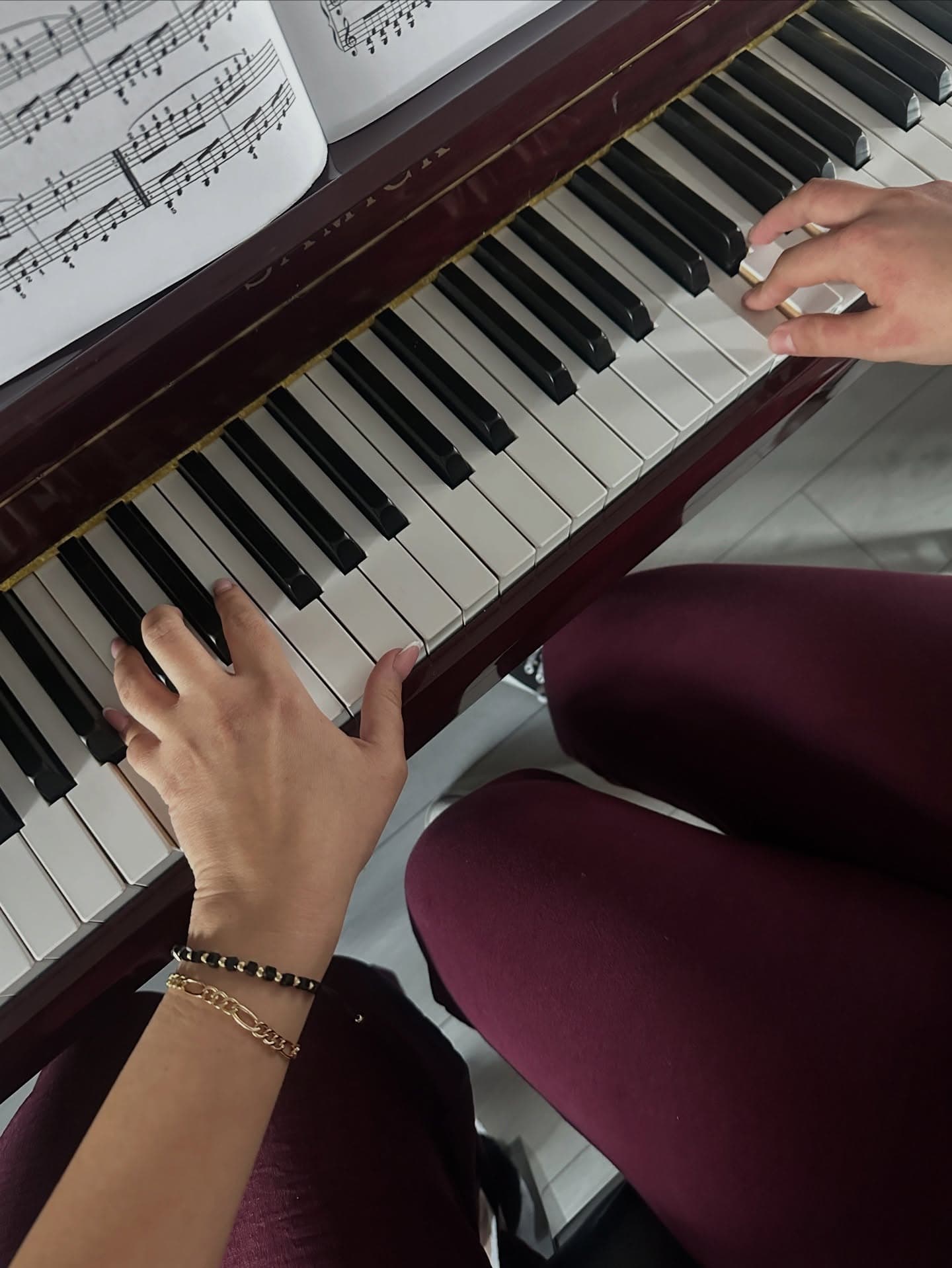 Handen op de pianotoetsen tijdens het spelen van bladmuziek